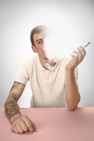 Bonito hipster fumando cigarro em casa. Homem olhando para cima e desfrutando de passar o tempo livre . — Fotografia de Stock