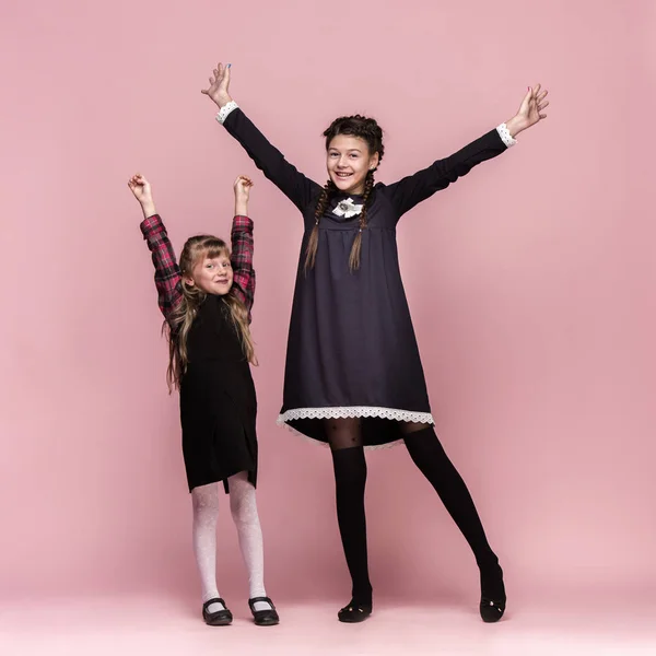 Enfants élégants mignons sur fond de studio rose. Les belles adolescentes debout ensemble — Photo