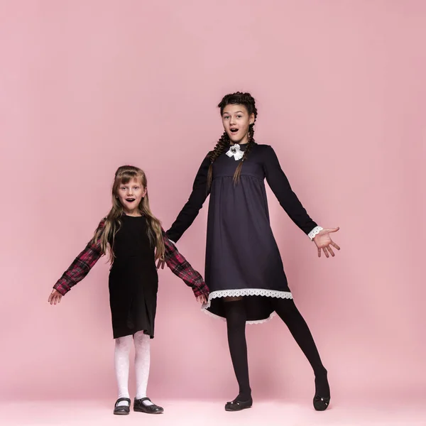 Enfants élégants mignons sur fond de studio rose. Les belles adolescentes debout ensemble — Photo