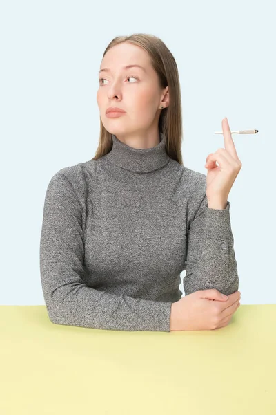 Красивые молодые женщины курят, сидя за столом в студии. Модные цвета — стоковое фото