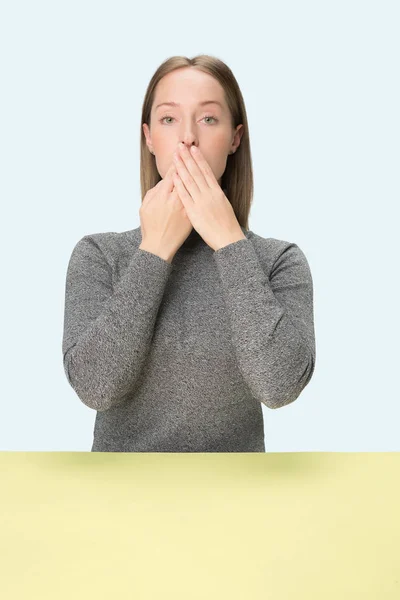 Młoda kobieta zakrywa usta — Zdjęcie stockowe