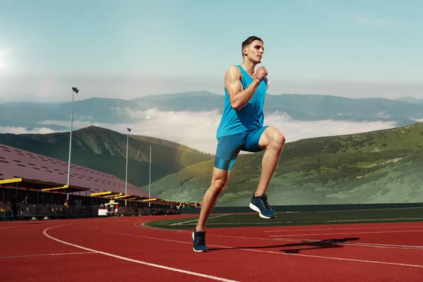Man kör i spåret. Fit manliga fitness löpare jogging i stadium — Stockfoto