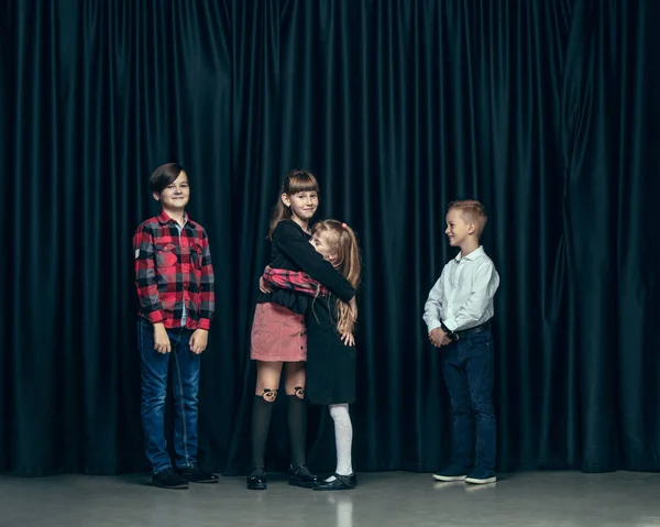 Lindos niños con estilo en el fondo del estudio oscuro. La hermosa adolescente niñas y el niño de pie juntos — Foto de Stock