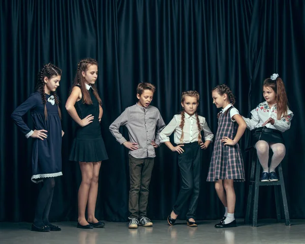 Carino bambini eleganti su sfondo scuro studio. La bella teen ragazze e ragazzo in piedi insieme — Foto Stock