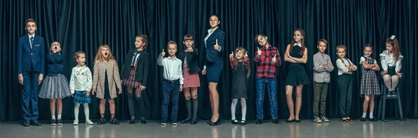 어두운 스튜디오 배경 귀여운 세련 된 아이 들. 아름 다운 십 대 소녀와 함께 서 있는 소년 — 스톡 사진