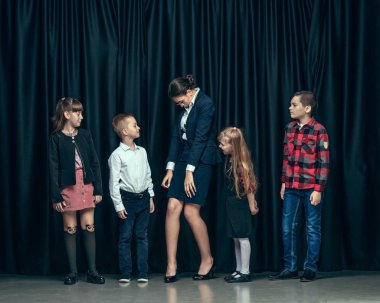 Karanlık studio arka plan üzerinde şirin şık çocuk. Güzel genç kız ve erkek birlikte ayakta