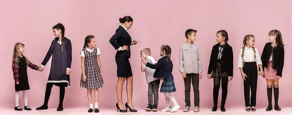Bonito crianças elegantes no fundo do estúdio rosa. As meninas adolescentes bonitas e menino de pé juntos — Fotografia de Stock