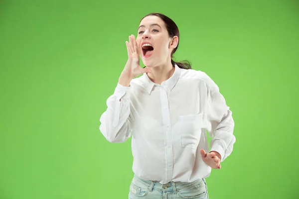 Isolato su verde giovane donna casuale gridando in studio — Foto Stock