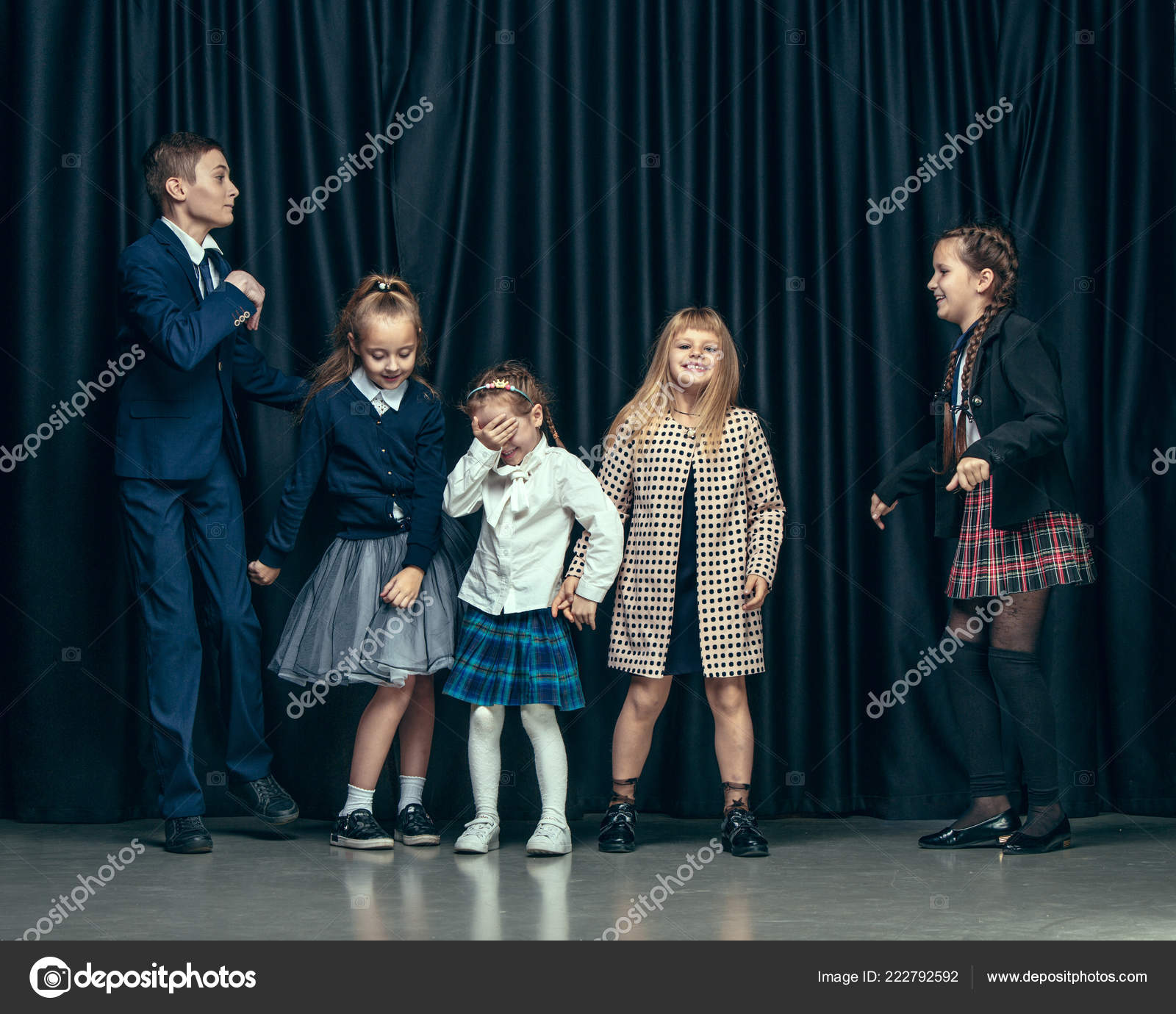 Cute stylish children on dark studio background. The beautiful teen girls  and boy standing together Stock Photo by ©vova130555@ 222792592
