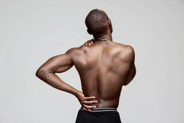 Junger Mann mit Rückenschmerzen isoliert auf weiß — Stockfoto