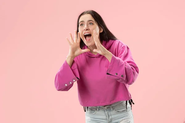 Ізольовані на рожевій молодій випадковій жінці, що кричить на студії — стокове фото