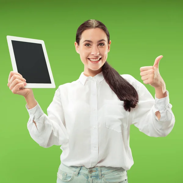 Portrét jistý neformální dívka zobrazení prázdné obrazovky notebooku nad zeleným pozadím, samostatný — Stock fotografie