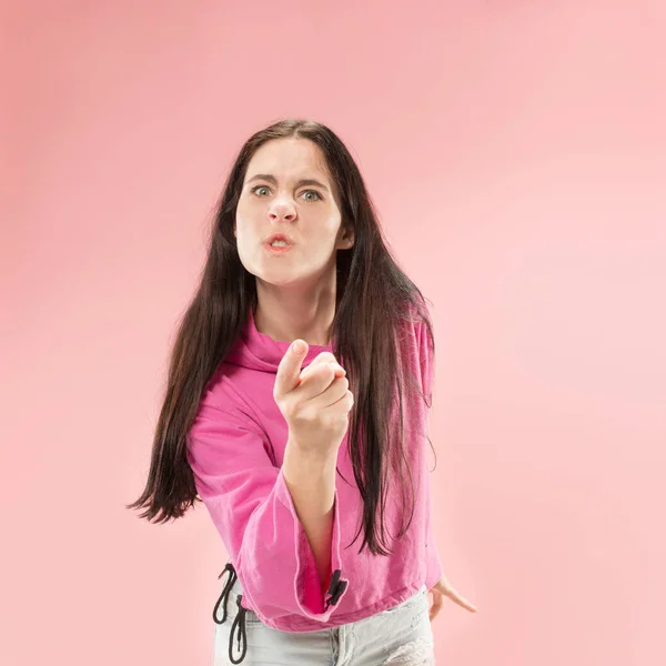 一个愤怒的女人的肖像看着相机在粉红色背景下隔离 — 图库照片
