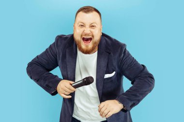 Genç adam kavramı lider mavi arka plan üzerinde mikrofon ile