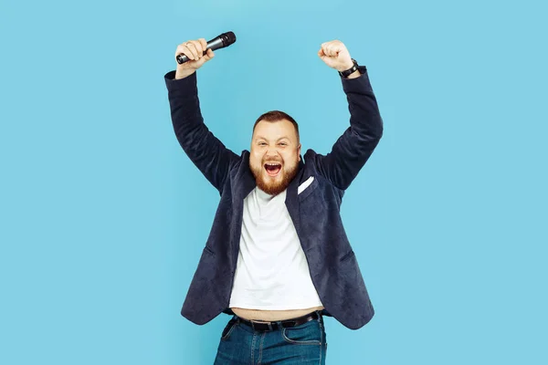 Jeune homme avec microphone sur fond bleu, concept leader — Photo