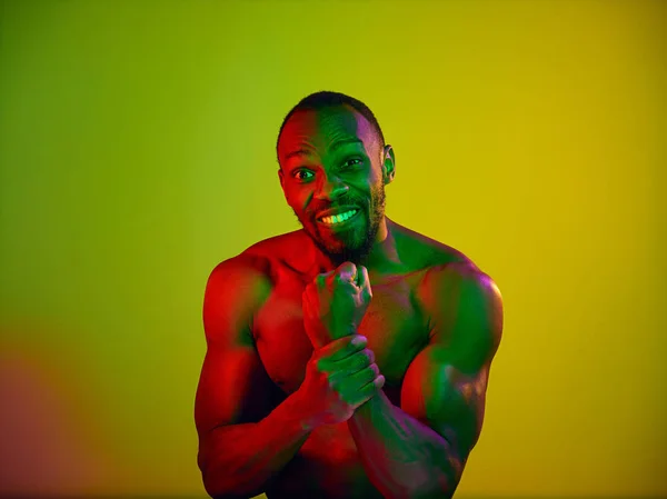 Close up portrait of a young naked african man looking at camera indoors