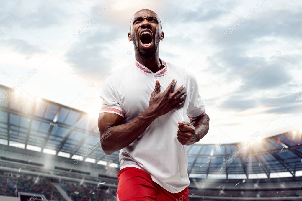 The football player in motion on the field of stadium