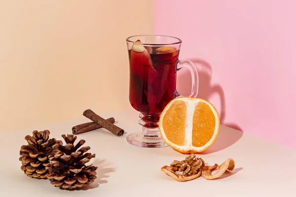 Mulled κρασί σε ποτήρι με στικ κανέλας, Χριστουγεννιάτικα γλυκά στο στο γυάλινο τραπέζι — Φωτογραφία Αρχείου