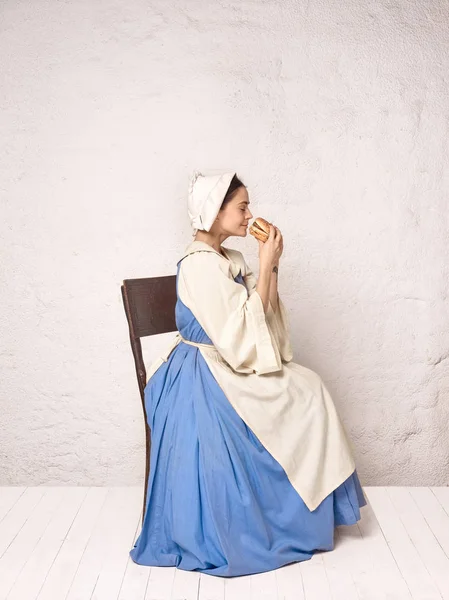 Средневековая женщина в историческом костюме в корсетном платье и капоте . Стоковая Картинка