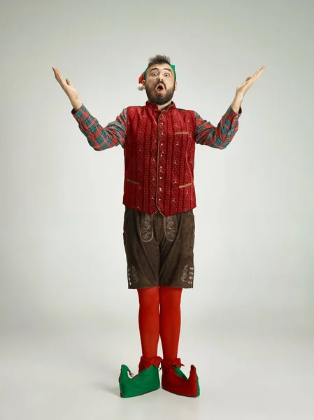 Hombre amigable vestido como un gnomo divertido posando sobre un fondo gris aislado — Foto de Stock