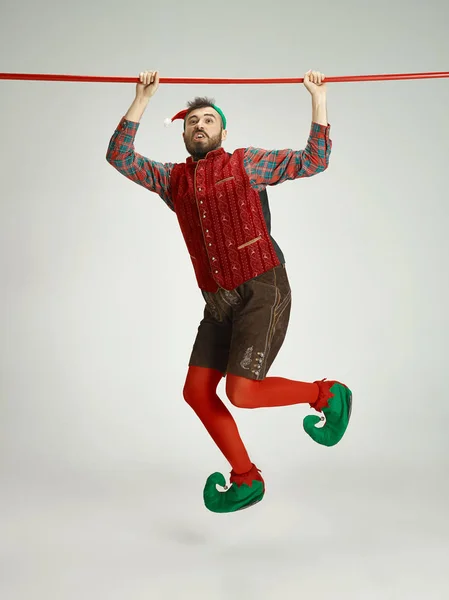 Hombre amigable vestido como un gnomo divertido posando sobre un fondo gris aislado — Foto de Stock