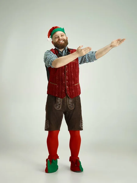 Hombre amigable vestido como un gnomo divertido posando sobre un fondo gris aislado — Foto de Stock