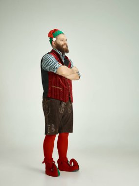 izole gri arka plan üzerinde poz komik cüce gibi giyinmiş dostça adam