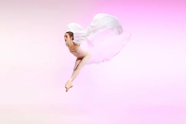 Ballerina. Unga graciösa kvinnliga dansare dansar över rosa studio. Skönheten i klassisk balett. — Stockfoto