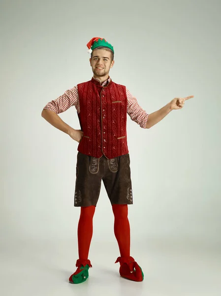 Friendly man dressed like a funny gnome posing on an isolated gray background — Stock Photo, Image