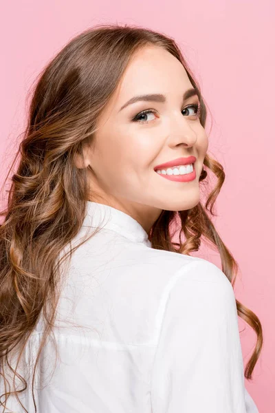 La mujer de negocios feliz de pie y sonriendo sobre el fondo rosa . — Foto de Stock