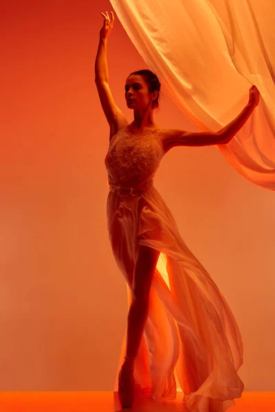 Балерина. Молодая грациозная балетная танцовщица танцует над красной студией. Красота классического балета . — стоковое фото