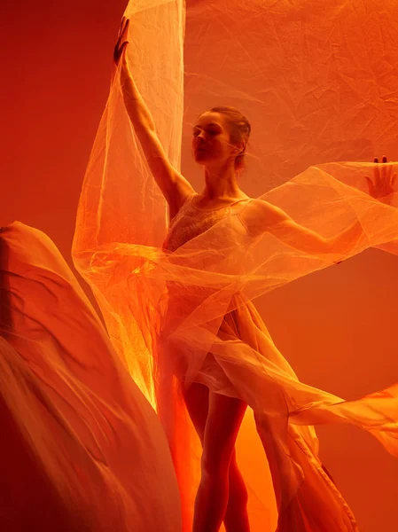 Ballerina. Jonge sierlijke vrouwelijke balletdanser dansen over rode studio. Schoonheid van klassiek ballet. — Stockfoto