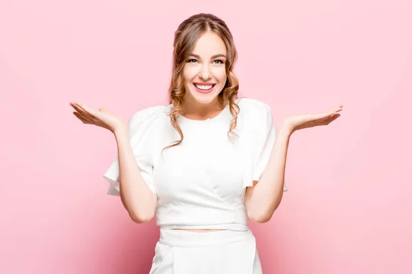 A mulher de negócios feliz de pé e sorrindo contra fundo rosa . — Fotografia de Stock