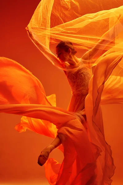 Балерина. Молодая грациозная балетная танцовщица танцует над красной студией. Красота классического балета . — стоковое фото