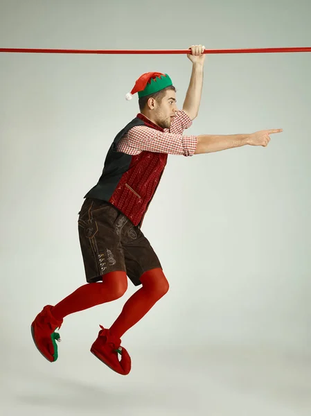 Hombre amigable vestido como un gnomo divertido posando sobre fondo gris — Foto de Stock