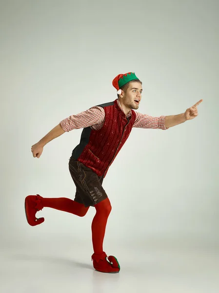 Barátságos ember öltözött, mint egy vicces gnome pózol a szürke háttér — Stock Fotó