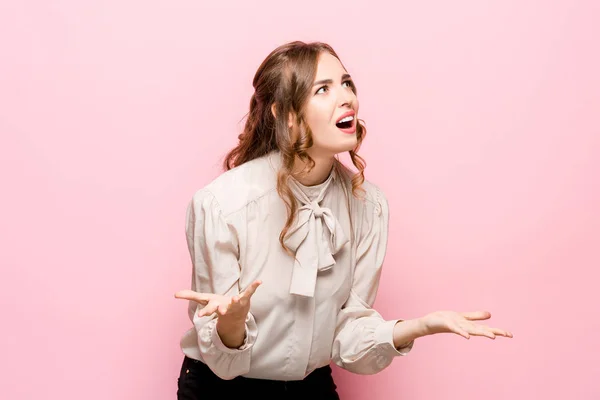 Hermoso retrato femenino de media longitud aislado en el fondo del estudio rosa. La joven mujer emocional sorprendida —  Fotos de Stock