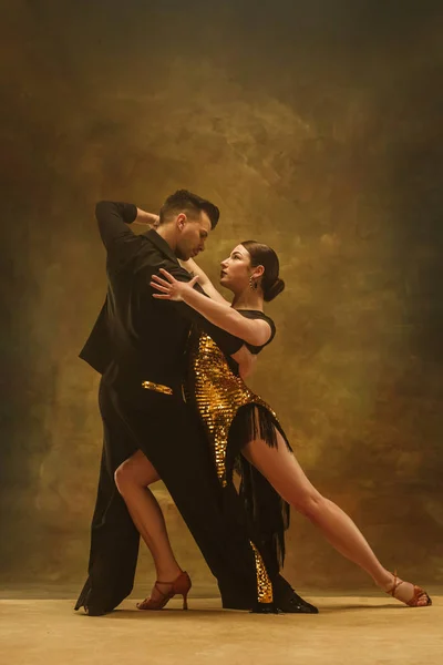 Altın elbiseli studio arka üzerinde dans balo salonu çift dans. — Stok fotoğraf