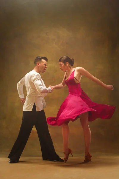 ダンス スタジオの背景にゴールドのドレスで社交カップルを踊る. — ストック写真