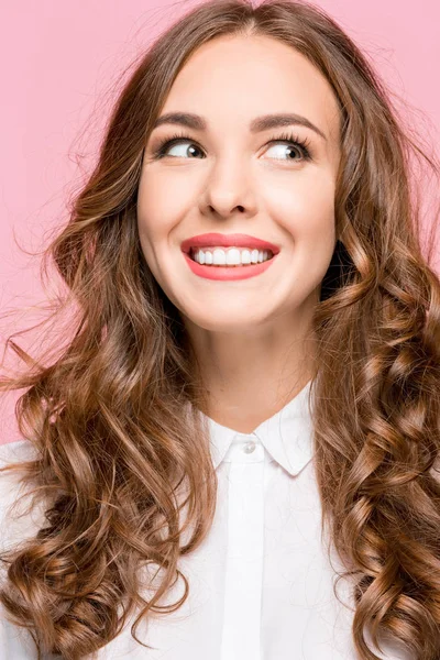 A mulher de negócios feliz de pé e sorrindo contra fundo rosa . — Fotografia de Stock