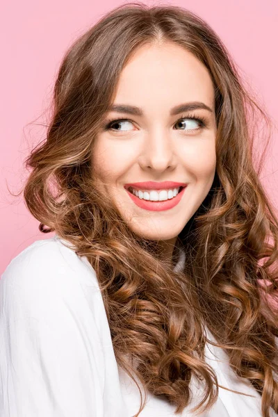 A mulher de negócios feliz de pé e sorrindo contra fundo rosa . — Fotografia de Stock