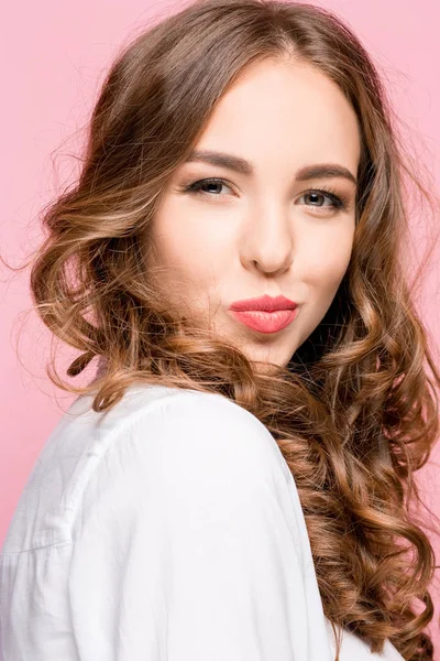 Портрет привлекательной милой девушки с ярким макияжем с поцелуем изолированы на розовом фоне — стоковое фото