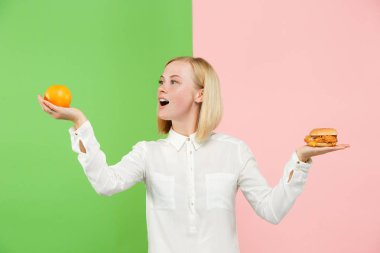 Diyet. Diyet kavramı. Sağlıklı gıda. Güzel genç kadın meyve ve unhelathy lokanta arasında seçim yapma