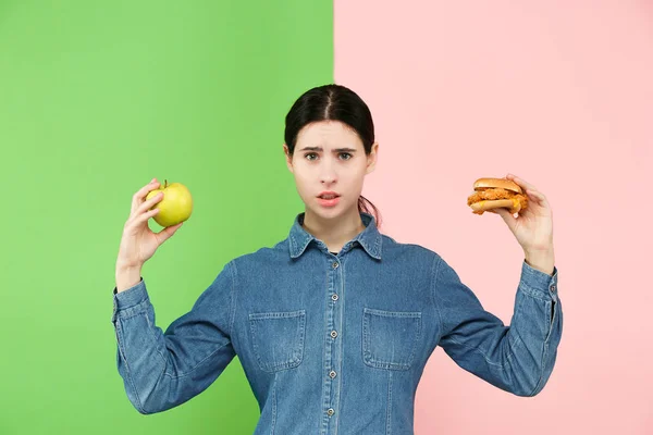 Diyet. Diyet kavramı. Sağlıklı gıda. Güzel genç kadın meyve ve unhelathy lokanta arasında seçim yapma — Stok fotoğraf