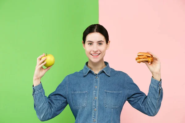 Diyet. Diyet kavramı. Sağlıklı gıda. Güzel genç kadın meyve ve unhelathy lokanta arasında seçim yapma — Stok fotoğraf