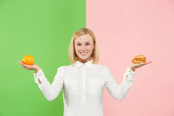 Strava. Pojem dieta. Zdravé jídlo. Krásná mladá žena volba mezi ovoce a unhelathy rychlé občerstvení — Stock fotografie