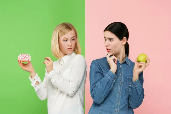 饮食。节食的概念。健康食品。美丽的年轻妇女选择水果和不健康蛋糕之间 — 图库照片