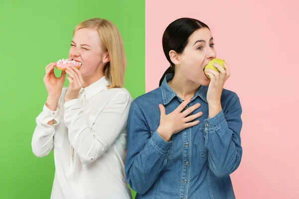 Dieta. Il concetto di dieta. Cibo sano. Belle giovani donne che scelgono tra frutta e torta unhelathy — Foto Stock