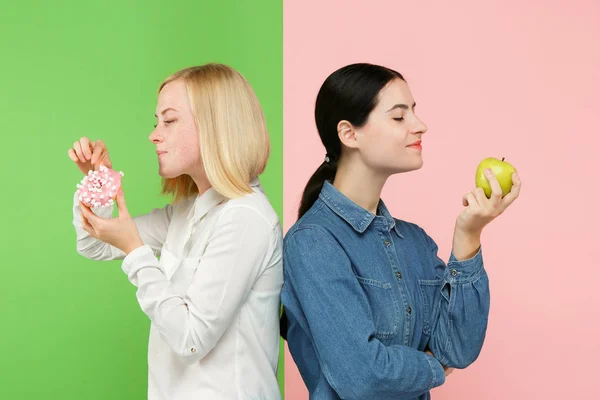 Dieta. Il concetto di dieta. Cibo sano. Belle giovani donne che scelgono tra frutta e torta unhelathy — Foto Stock