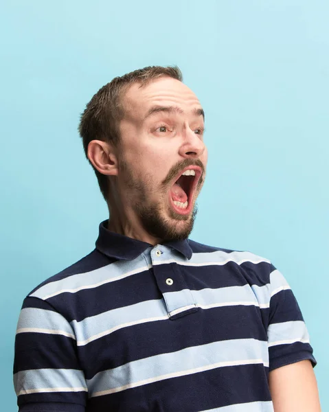 O homem gritando com a boca aberta isolado no fundo azul, conceito de emoção rosto — Fotografia de Stock